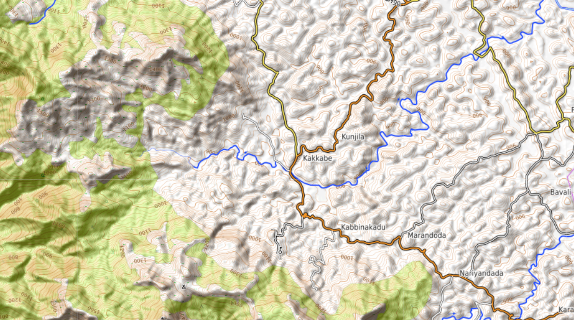 Survey extract of Kakkabe, Kunjila and Kabbinakadu showing dense small hill contours, the orange district road and blue river lines
